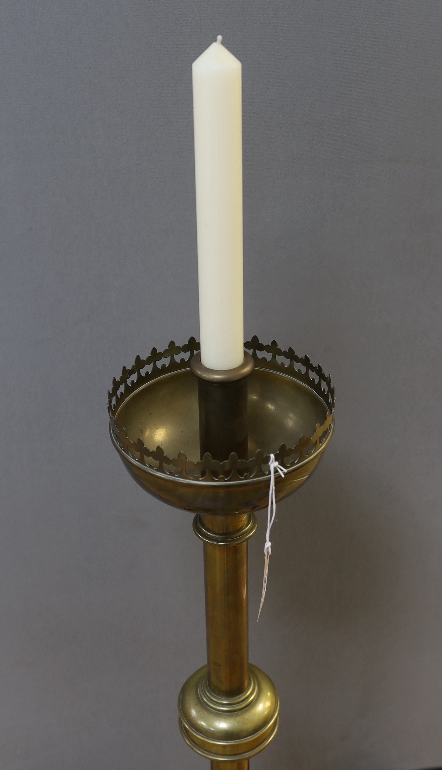 A large brass ecclesiastical candlestick with gothic border, 98cm high